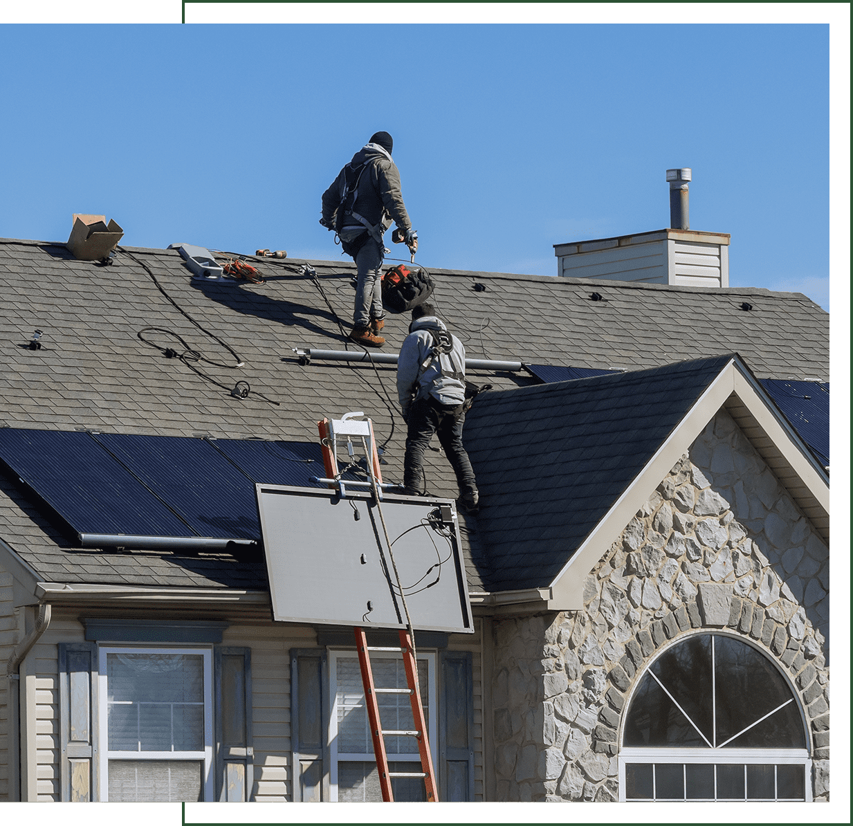Workers installing solar panels on roof.