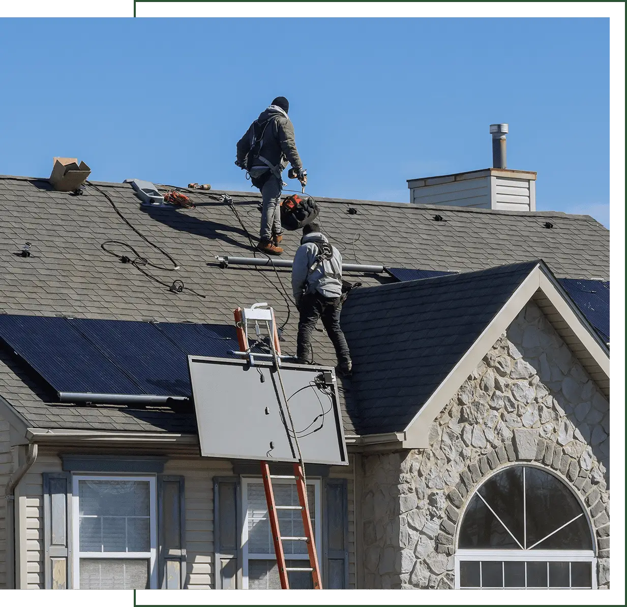 Crew hoisting a large solar panel by ladder