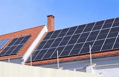 Solar panels on red-tiled rooftop.
